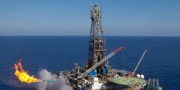 Een olieplatform op zee is gas aan het affakkelen (flaring).