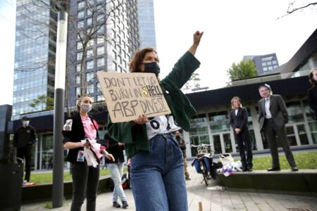 Demonstrant met protestbord: 'Don't let us burn in (s)hell, ABP, divest!'