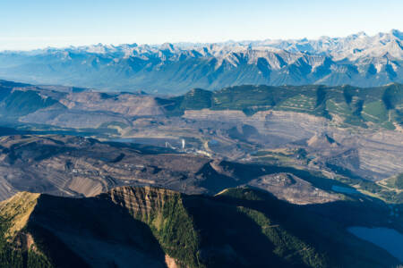 Luchtfoto van afgegraven gebied, met op de achtergrond bergtoppen.
